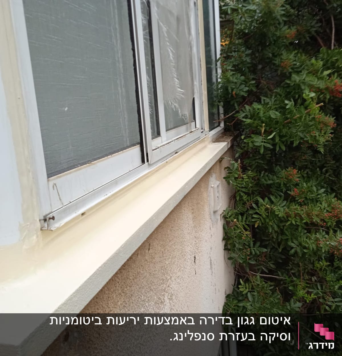 חלון אטום עם חומר איטום לבן על מסגרת מתכת